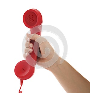 Woman holding red corded telephone handset on white background, closeup. Hotline concept