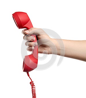 Woman holding red corded telephone handset on white background, closeup. Hotline concept