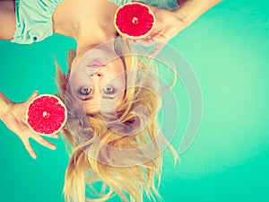 Woman holding red grapefruit having crazy windblown hair