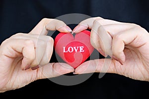 A woman holding a red heart