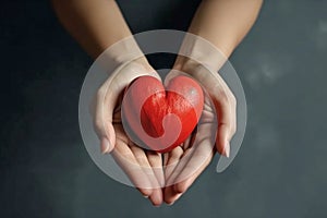 Woman holding a red heart, concept for charity