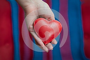 Woman holding red heart, health ,  world heart day, self care , healthy lifestyle concept on a red and blue background