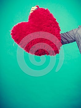 Woman holding red pillow in heart shape