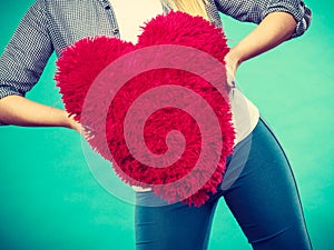 Woman holding red pillow in heart shape