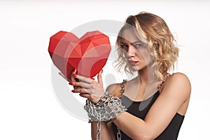 Woman holding red polygonal paper heart shape with tied by chain hands