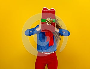 Woman holding red present box in the front of her face