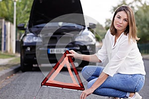 woman holding red triangle on road