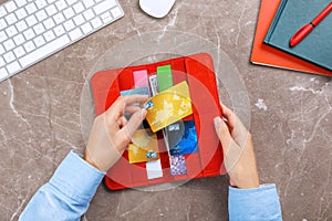 Woman holding red wallet with credit cards