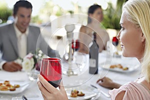 Woman Holding Red Wineglass At Party