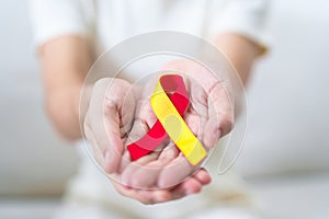 woman holding Red and Yellow ribbon. World hepatitis day awareness month, 28 July, Liver cancer, Jaundice, Cirrhosis, Failure,