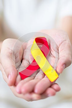 woman holding Red and Yellow ribbon. World hepatitis day awareness month, 28 July, Liver cancer, Jaundice, Cirrhosis, Failure,