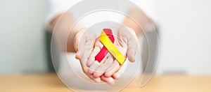 woman holding Red and Yellow ribbon. World hepatitis day awareness month, 28 July, Liver cancer, Jaundice, Cirrhosis, Failure,