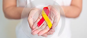 woman holding Red and Yellow ribbon. World hepatitis day awareness month, 28 July, Liver cancer, Jaundice, Cirrhosis, Failure,