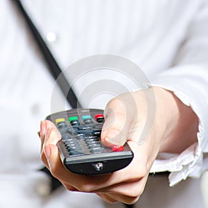 Woman holding remote control and pushing power button