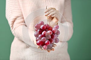 Woman holding ripe juicy grapes, closeup