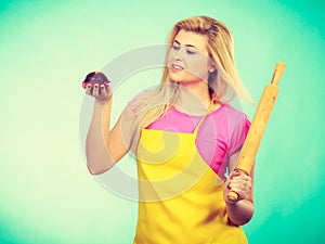 Woman holding rolling pin and chocolate cupcake
