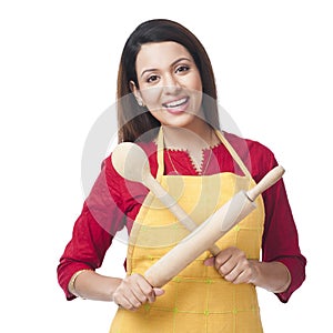 Woman holding rolling pin and wooden spoon