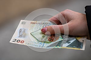 Woman holding Romanian LEI money, 200 LEI banknote