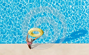 Woman holding rubber ring overhead at poolside