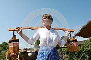 Woman holding russian yoke with buckets