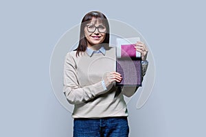 Woman holding samples of fabrics for interior, on grey background