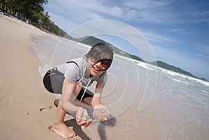 Woman holding sand on beach