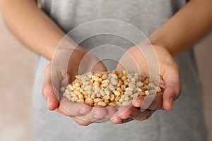 Woman holding shelled pine nuts, closeup.