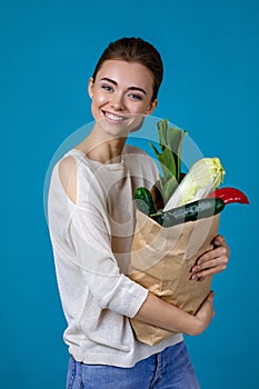 Woman holding a shopping bag full of groceries