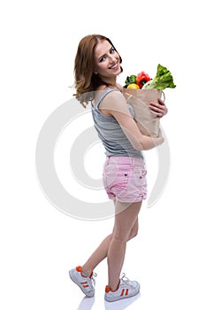 Woman holding a shopping bag full of groceries