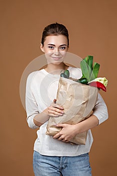 Woman holding a shopping bag full of groceries