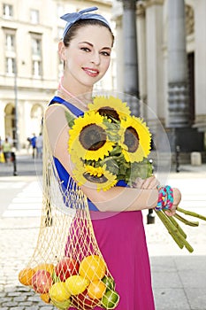 Woman holding shopping bags against