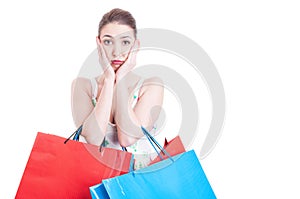 Woman holding shopping bags and feeling worried or afraid