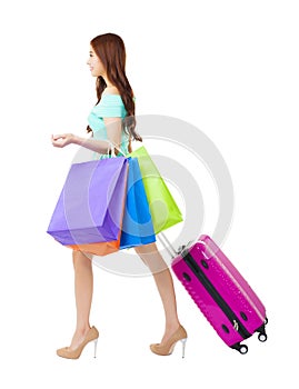 woman holding shopping bags and travel suitcase