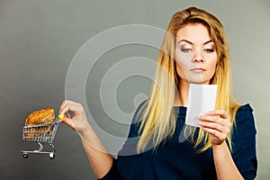 Woman holding shopping basket with bread