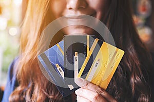 A woman holding and showing credit cards