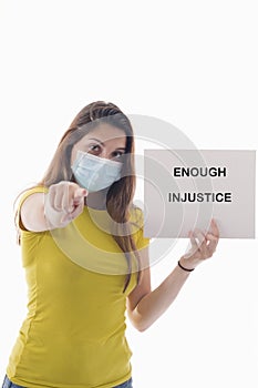 Woman holding a sign with a message and pointing at the camera. Racism and awareness concept