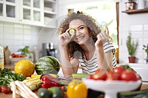 Woman holding a slice of cucumber