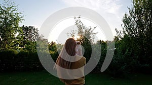 Woman holding a small cute Chihuahua puppy at sunset.