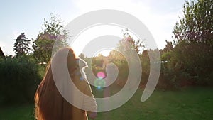 Woman holding a small cute Chihuahua puppy at sunset.