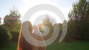 Woman holding a small cute Chihuahua puppy at sunset.