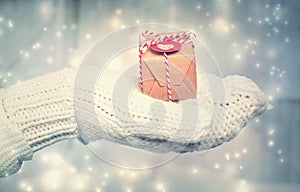 Woman holding a small gift box with heart tag