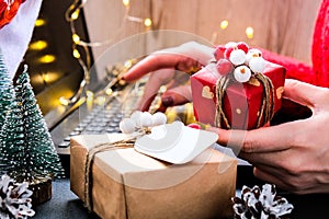 Woman holding small present box in hand and using search by laptop. Christmas Concept. Online shopping. Holiday sale