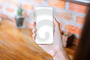 woman holding smart phone with blank screen while sitting at the living room