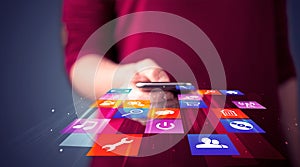 Woman holding smart phone with colorful application icons