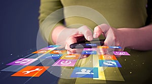 Woman holding smart phone with colorful application icons
