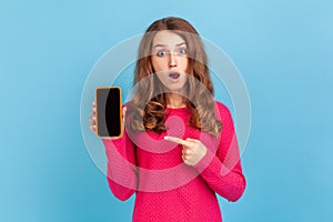 Woman holding smart phone in hands with blank display for advertisemant. photo