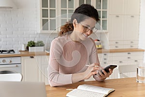 Woman holding smartphone and pencil, check schedule planning household