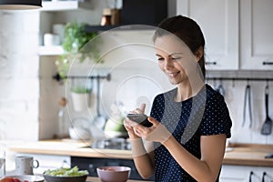 Woman holding smartphone use cookbook apps search recipes on internet