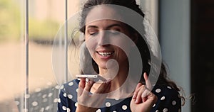 Woman holding smartphone use speakerphone leave audio message to friend