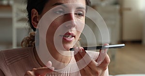 Woman holding smartphone using speakerphone recording and leaving audio message